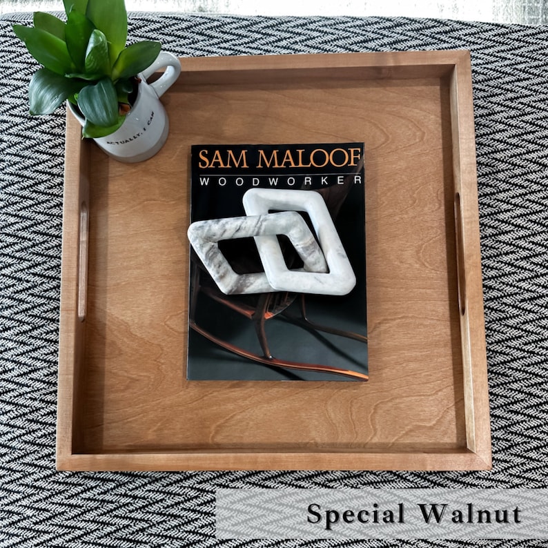 K&ouml;nnte beinhalten: Ein Tablett aus Holz mit einem Magazin mit dem Titel "Sam Maloof Woodworker" darauf. Das Tablett ist aus Spezialwalnuss gefertigt und hat zwei Griffe an den Seiten.