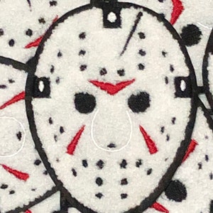 May include: A white hockey mask with black straps and red accents. The mask has a distressed look with black dots and lines throughout.
