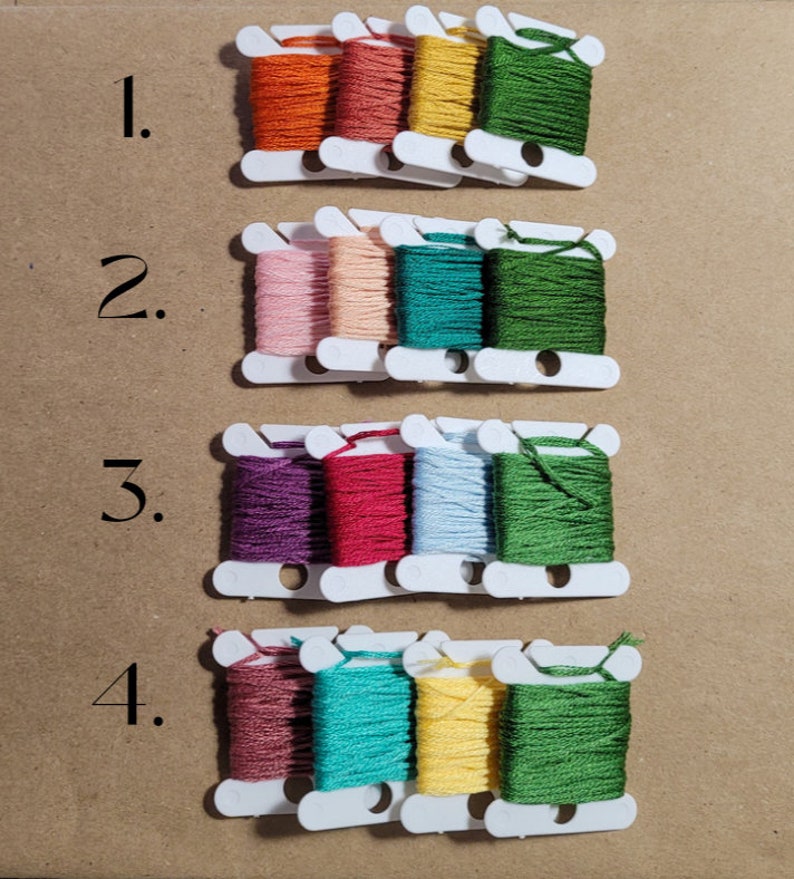 May include: Four rows of embroidery floss spools, each row with four spools. Row 1: orange, red, yellow, green. Row 2: pink, beige, teal, green. Row 3: purple, red, light blue, green. Row 4: brown, teal, yellow, green. The rows are numbered 1 through 4.