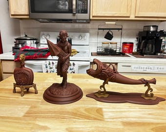 May include: A collection of brown decorative items on a wooden surface. The items include a bottle with a stand, a statue of a mythical creature holding an umbrella, and a horn-shaped object with a dragon head.