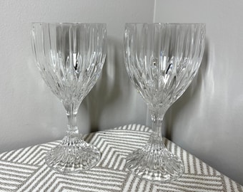Könnte beinhalten: Zwei klare Weingläser aus Glas mit geschnittenem Kristallmuster. Die Gläser stehen auf einer grauen und weißen gemusterten Oberfläche.