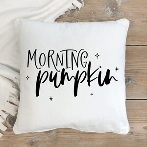 May include: White throw pillow with black text that reads "Morning Pumpkin" and small star accents.