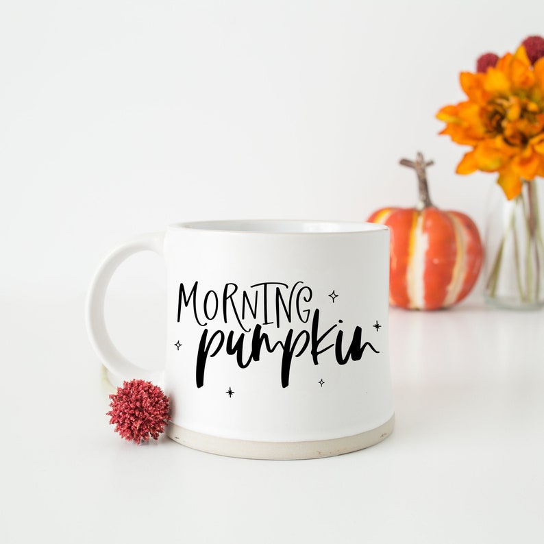 May include: White ceramic mug with black text that reads "Morning Pumpkin" with small stars around the text.