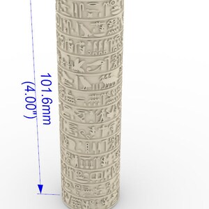 Puede incluir: Un objeto cilíndrico beige con jeroglíficos tallados en la superficie. El objeto mide 10,16 cm de alto y 2,54 cm de diámetro.