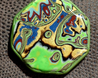 May include: A colorful, hexagonal pendant with a marbled design. The pendant features swirls of gold, blue, red, and green, with a bright green border. The abstract pattern creates a unique, eye-catching accessory.