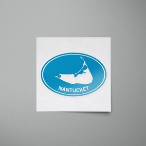 May include: A blue oval sticker with a white outline of the island of Nantucket and the word "NANTUCKET" printed in white.