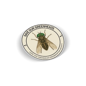 May include: A circular sticker with a detailed illustration of a greenhead fly, with prominent green eyes. The sticker includes the text "SAVE OUR GREENHEADS" and "CAPE COD GREENHEAD PRESERVATION SOCIETY" in a circular arrangement.