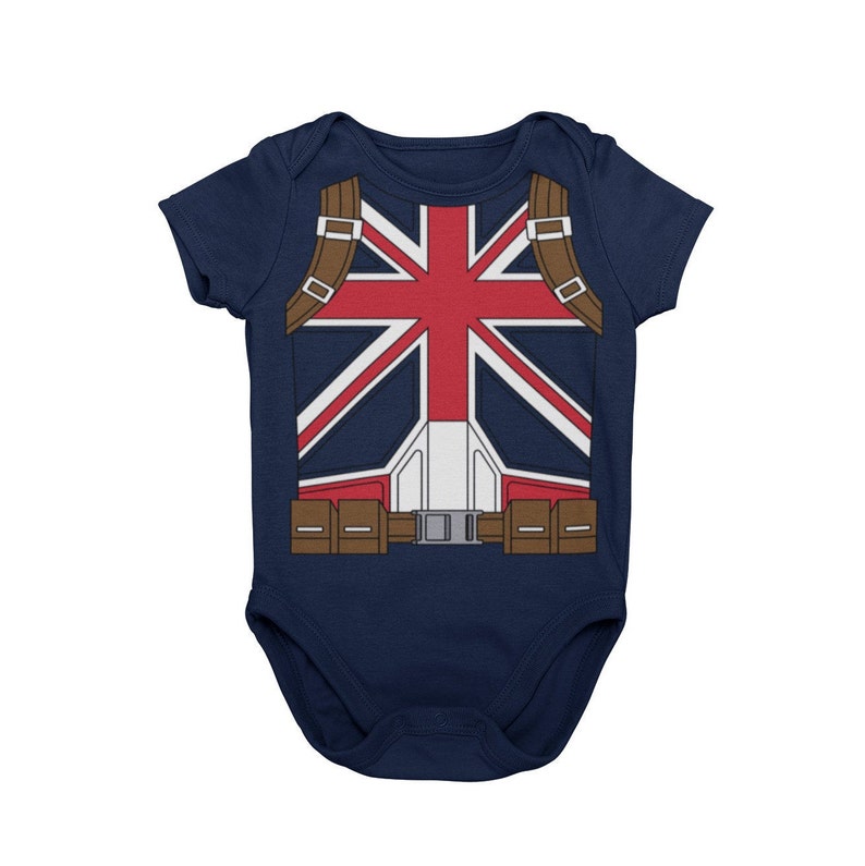May include: A navy blue baby onesie with a red, white, and blue Union Jack flag design on the front. The onesie has a brown belt and straps.