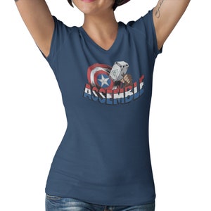 Puede incluir: Una camiseta azul marino de cuello en V con un gr&aacute;fico del escudo del Capit&aacute;n Am&eacute;rica y el martillo de Thor con el texto "ASSEMBLE".