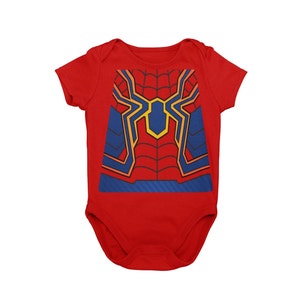 May include: Red baby onesie with a graphic print of a superhero's chest design in red, blue, and yellow.