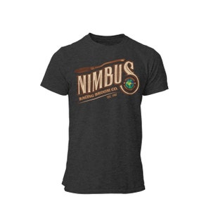 Könnte beinhalten: Dunkelgraues T-Shirt mit einem braunen und weißen Logo, auf dem "Nimbus Racing Broom Co. Est. 1967" steht. Das Logo zeigt einen stilisierten Besen und einen Globus.