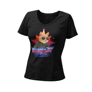 Op de afbeelding: Zwart V-hals T-shirt met een kat met een zonnebril en een vliegpak, tegen een rood sterontwerp. Het woord "GOOSE" wordt in een retro lettertype onder de kat weergegeven, met blauwe en rode accenten.