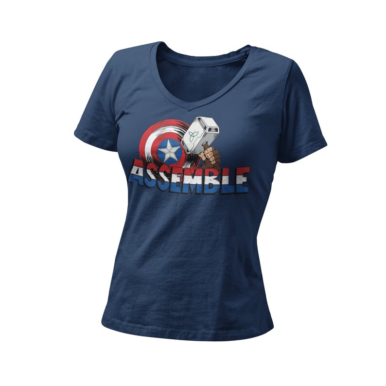 Puede incluir: Una camiseta azul marino de cuello en V con un gr&aacute;fico del escudo del Capit&aacute;n Am&eacute;rica y el martillo de Thor con el texto "ASSEMBLE".