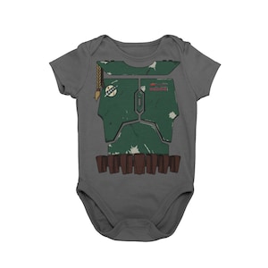 May include: A gray baby onesie with a green and brown Boba Fett costume design printed on the front. The design includes a brown belt with pouches and a braided antenna.