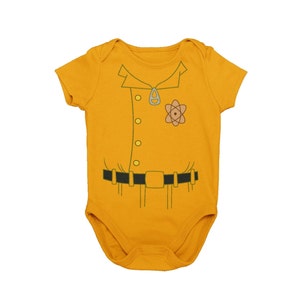 May include: A yellow baby onesie with a cartoon image of a scientist wearing a lab coat, a belt, and an atom symbol on the chest.