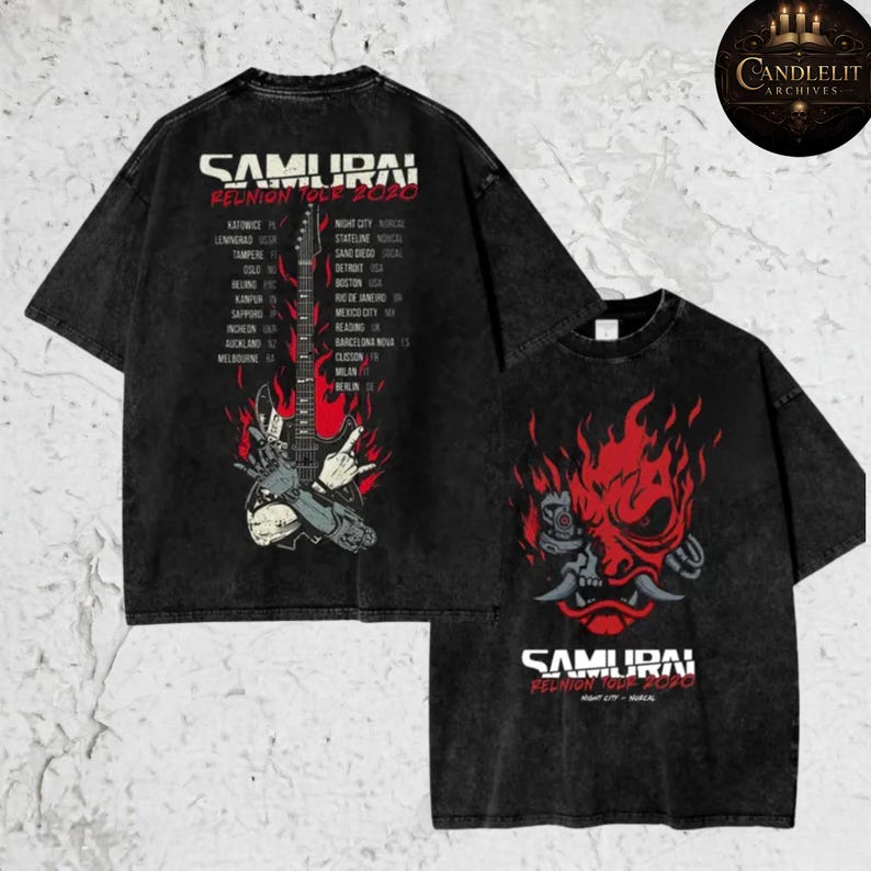 May include: Black, acid-wash t-shirts featuring the text "SAMURAI REUNION TOUR 2020" with a graphic of a guitar and a list of tour cities on the back. The front of the shirt displays a red oni mask design.