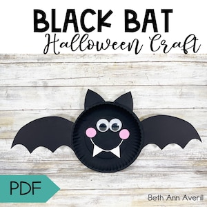 Puede incluir: Una manualidad de Halloween de murciélago negro hecha con un plato de papel, con ojos saltones, mejillas rosas y colmillos blancos. El murciélago tiene grandes alas y orejas negras. Las palabras "BLACK BAT Halloween Craft" están en la parte superior.