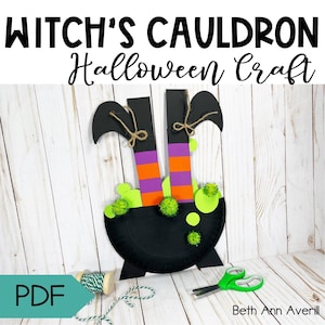 Peut inclure: Un bricolage d'Halloween représentant un chaudron noir avec des jambes de sorcière dans des bas rayés orange et violets. Le chaudron est décoré de pompons verts et de papier vert. Le texte "WITCH'S CAULDRON Halloween Craft" est en haut.