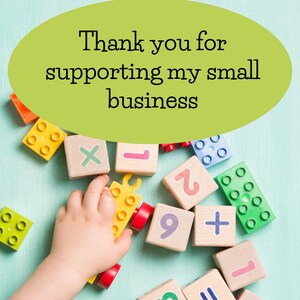May include: A child's hand reaches for a yellow toy truck with red wheels. The truck is surrounded by colorful wooden blocks with numbers, letters, and symbols. The text "Thank you for supporting my small business" is written in a green oval.