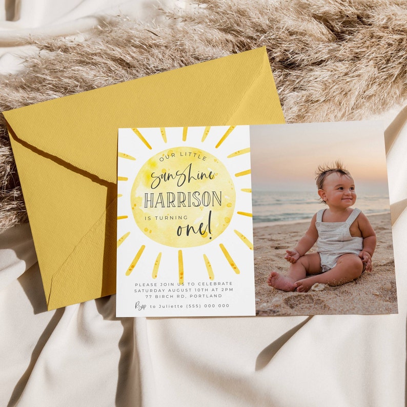 May include: A rectangular birthday invitation card featuring a yellow watercolor sun graphic with the text Our Little Sunshine Harrison Is Turning One, alongside a photograph of a toddler on a beach, paired with a mustard yellow envelope.