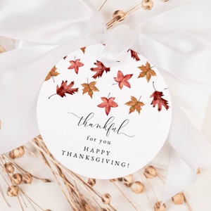 Może przedstawiać: Okrągła biała etykieta prezentowa z wzorem czerwonych i pomarańczowych liści akwarelowych. Etykieta zawiera napis "thankful for you happy thanksgiving!"