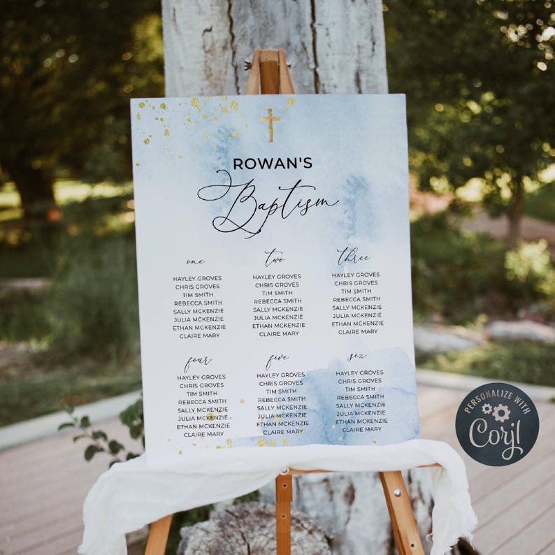 May include: A baptism seating chart on an easel. The sign has a watercolor wash background in shades of blue and gold. The text "Rowan's Baptism" is at the top, with guest names listed below, organized by table number.