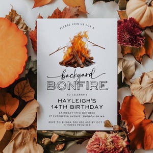 May include: A white invitation card with black text and a drawing of a campfire with marshmallows on sticks. The text reads "Please join us for a backyard bonfire to celebrate Hayleigh's 14th birthday. Saturday 17th October, 27 Evergreen Avenue, Snohomish WA. RSVP to Sienna 500 000 000 by Oct 1. S'mores provided."