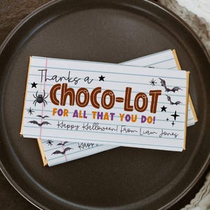 May include: Two chocolate bars with a Halloween theme. The wrappers feature the text "Thanks a Choco-LOT for all that you do! Happy Halloween! From Liam Jones" with bats, stars, and a spider graphic.