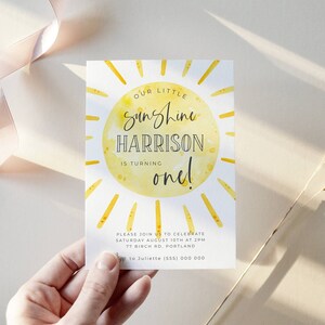 May include: A yellow and white sun with the text "Our Little Sunshine Harrison is turning one!"  Please join us to celebrate Saturday August 10th at 2pm 77 Birch Rd. Portland.  RSVP to Juliette (555) 000 000.