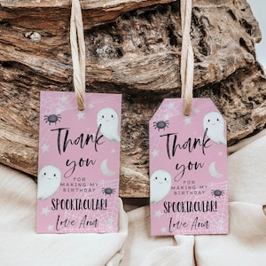 May include: Two pink thank you tags with a ghost and spider web design. The text reads "Thank you for making my birthday spooktacular! Love Aria."