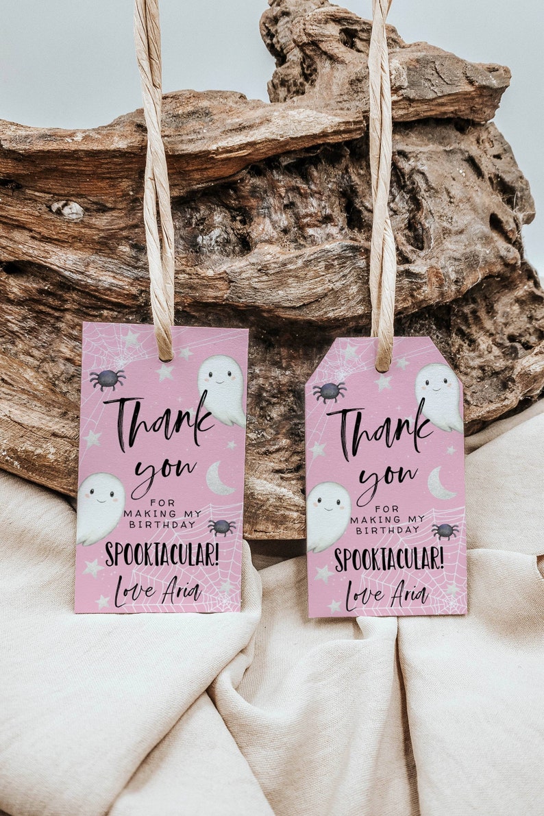 May include: Two pink thank you tags with a ghost and spider web design. The text reads "Thank you for making my birthday spooktacular! Love Aria."