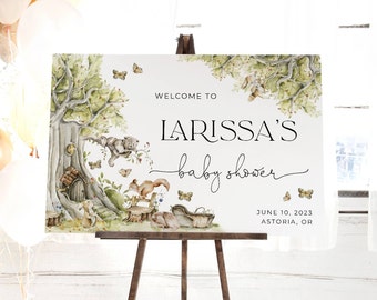 May include: Welcome to Larissa's baby shower sign with a woodland theme. The sign features a watercolor illustration of a tree, a squirrel, a bunny, and a bear. The text on the sign reads "Welcome to Larissa's baby shower" and includes the date and location of the event: June 10, 2023, Astoria, OR.