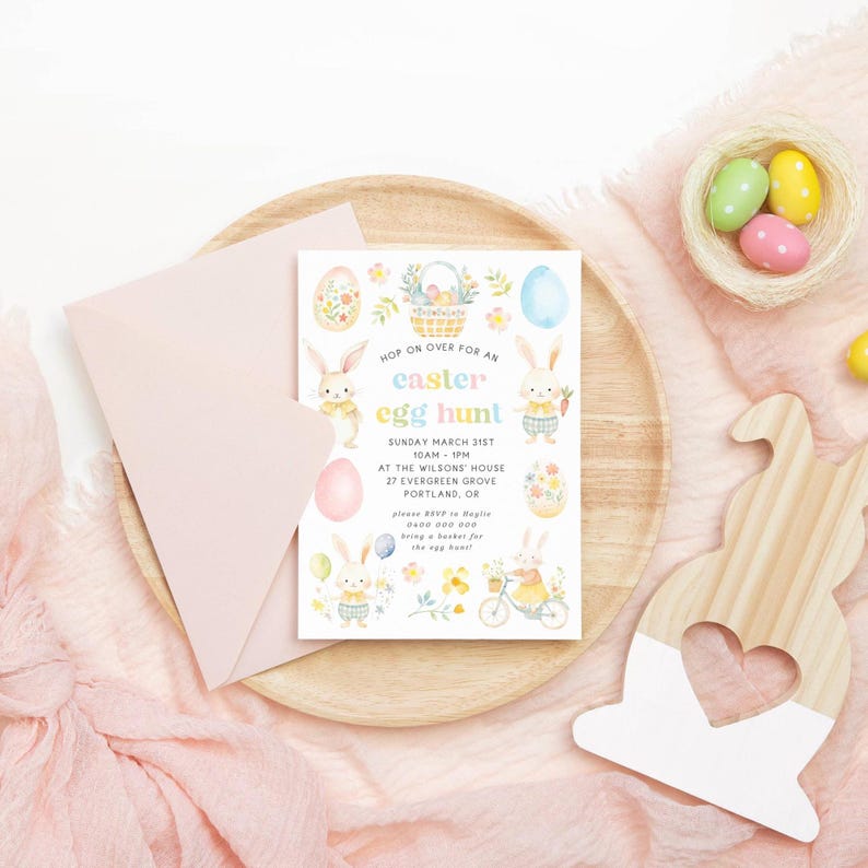 May include: An Easter-themed invitation with the text "Hop on over for an Easter egg hunt" and illustrations of bunnies and eggs. The invitation is on a wooden tray with a pink envelope and decorative wooden bunny.