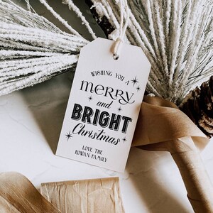 May include: White gift tag with black text that reads "Wishing you a merry and bright Christmas".  The text "Love the Rowan Family" is printed below the main message.