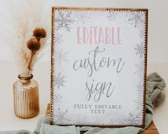 May include: Editable custom sign with a white background and silver snowflakes. The text "Editable custom sign" is in pink and silver glitter font. The text "Fully Editable Text" is in black font.