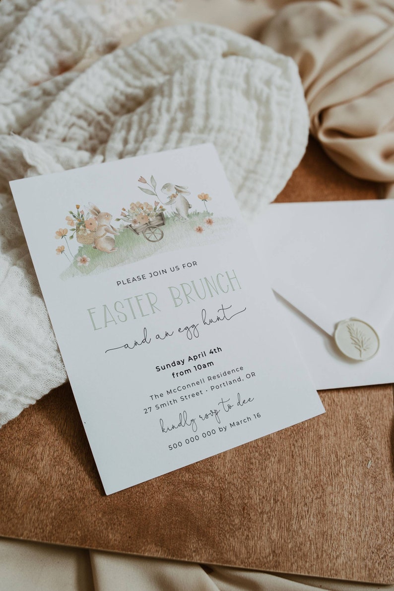 Pu&ograve; includere: Un invito bianco con un'illustrazione ad acquerello di due conigli che tengono fiori e una carriola. Il testo sulla carta recita "Si prega di unirsi a noi per il brunch di Pasqua e una caccia alle uova. Domenica 4 aprile dalle 10:00. La residenza McConnell 27 Smith Street Portland, OR gentilmente RSVP a dee 500 000 000 entro il 16 marzo."