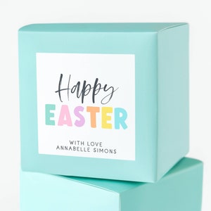 May include: A turquoise gift box with a white label that says "Happy Easter" in black script with the word "Easter" in colorful letters. The label also says "With love, Annabelle Simons".