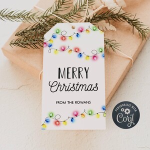 May include: White gift tag with a colorful string of Christmas lights and the text "Merry Christmas" and "From the Rowans".