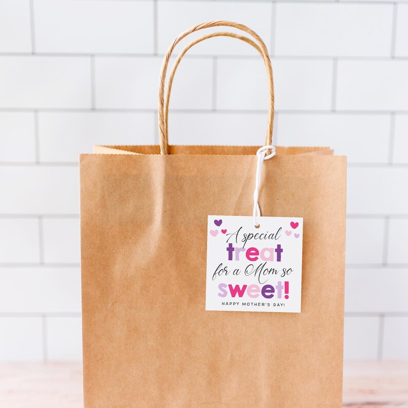 Może przedstawiać: Brązowa papierowa torba prezentowa z białą etykietą prezentową, na kt&oacute;rej napisano "A special treat for a Mom so sweet! Happy Mother's Day!" Etykieta ma r&oacute;żowe i fioletowe serduszka wok&oacute;ł tekstu.