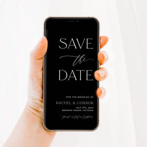 Könnte beinhalten: Ein Smartphone zeigt eine schwarze digitale Save the Date-Karte mit weißem Text: SAVE the DATE FOR THE WEDDING OF RACHEL & CONNOR JULY 7TH, 2024 BARWON HEADS, VICTORIA formal invitation to follow. Das Gerät hat einen dünnen goldenen Rahmen.