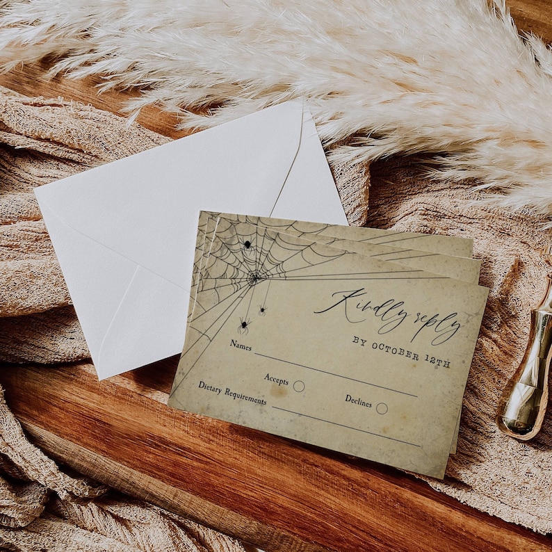 Puede incluir: Una tarjeta RSVP de estilo vintage con un dise&ntilde;o de telara&ntilde;a y el texto "Kindly reply by October 12th". La tarjeta tiene espacio para nombres, requisitos diet&eacute;ticos y una opci&oacute;n para aceptar o rechazar.
