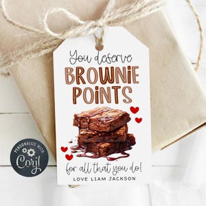 May include: White gift tag with brown and white text that reads "You deserve brownie points for all that you do! Love Liam Jackson". The tag features a drawing of a stack of chocolate brownies with chocolate sauce.