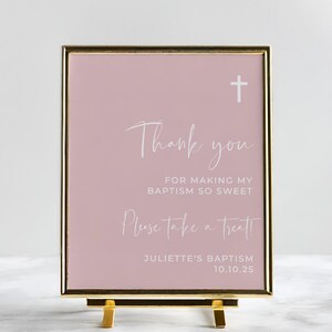 Peut inclure: Une pancarte rose avec un cadre dor&eacute; et un chevalet dor&eacute;. La pancarte indique "Merci d'avoir rendu mon bapt&ecirc;me si doux. Prenez un petit quelque chose !" et "Bapt&ecirc;me de Juliette 10.10.25".