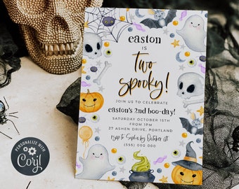 May include: A Halloween-themed invitation with the text "Easton is Two Spooky!" featuring illustrations of ghosts, pumpkins, bats, and skulls. A gold skull and toy spiders are in the background.