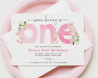 Puede incluir: Una tarjeta de invitación de cumpleaños rectangular con fondo blanco y puntos de confeti dorados. El texto dice: Some bunny is one, Hop on over to celebrate, Orla's First Birthday, Saturday, April 16th at 2pm, 27 Smith Street, Portland, RSVP to Larissa by April 6th - (543) 768 894. Incluye letras de acuarela rosa e ilustraciones de conejitos y ramos de flores.