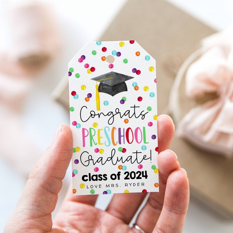 Puede incluir: Una etiqueta de regalo de graduaci&oacute;n colorida con confeti y un gorro de graduaci&oacute;n. La etiqueta dice "&iexcl;Felicidades, graduado de preescolar! Clase de 2024 Con cari&ntilde;o, Sra. Ryder".