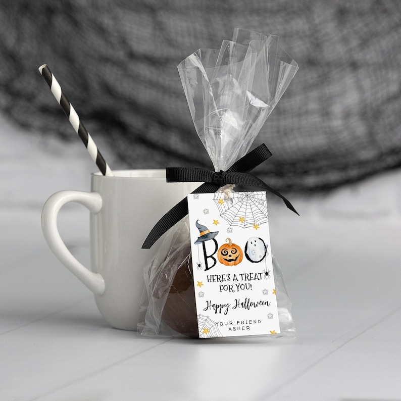 May include: A white gift tag with a black and orange pumpkin, a witch's hat, and a ghost. The tag says "BOO! Here's a treat for you! Happy Halloween. Your friend Asher."