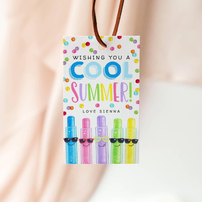May include: A gift tag with a brown leather string. The tag has the text "WISHING YOU A COOL SUMMER! LOVE SIENNA" in colorful letters. Below the text are five cartoon characters wearing sunglasses.
