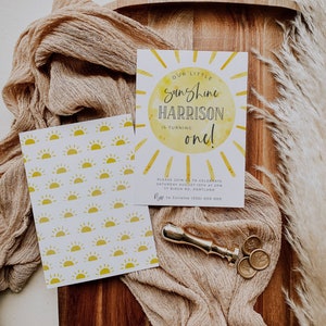 May include: A yellow and white birthday invitation with a sun graphic and the text "Our Little Sunshine Harrison is turning one!"  Please join us to celebrate Saturday August 10th at 2pm 77 Birch Rd, Portland RSVP to Juliette (555) 000 000
