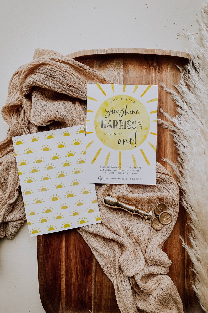 May include: A yellow and white birthday invitation with a sun graphic and the text "Our Little Sunshine Harrison is turning one!"  Please join us to celebrate Saturday August 10th at 2pm 77 Birch Rd, Portland RSVP to Juliette (555) 000 000